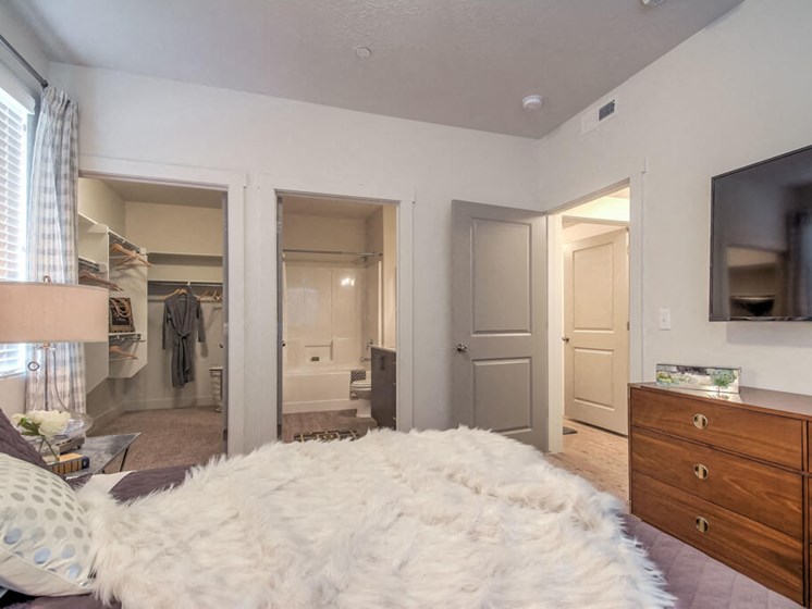 furnished model bedroom with walk-in closet and attached bathroom